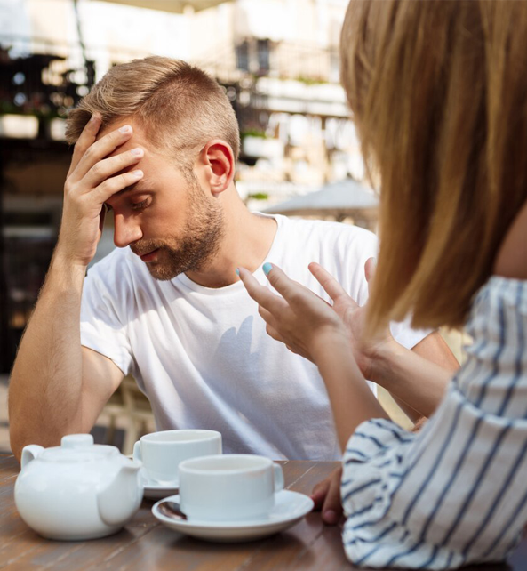 A couple that is fighting while taking their coffee.